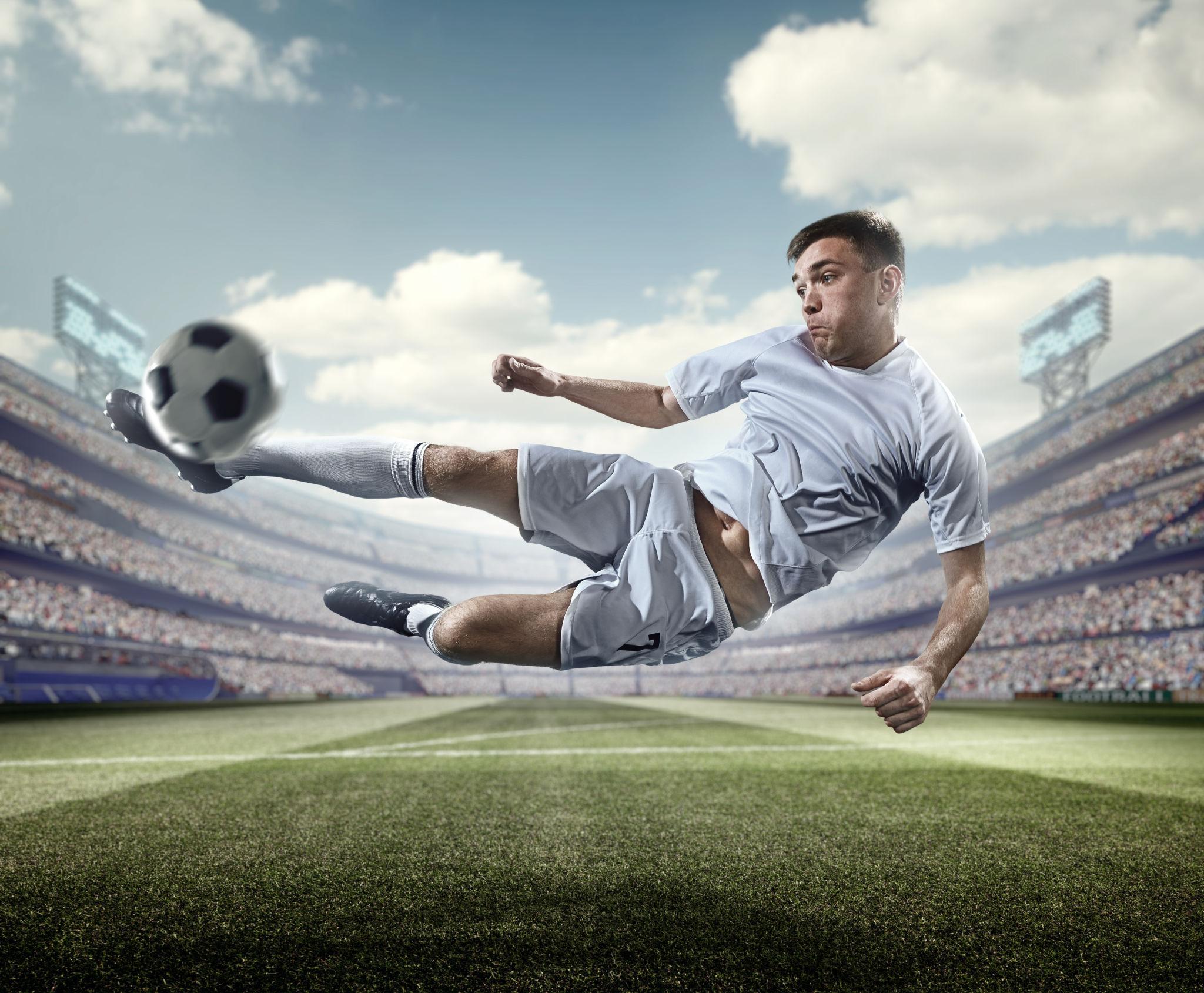 Soccer player kicking a ball during a stadium match